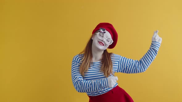 Happy Mime Woman in Beret and Round Glasses Happily Dances on an Orange Background Concept of