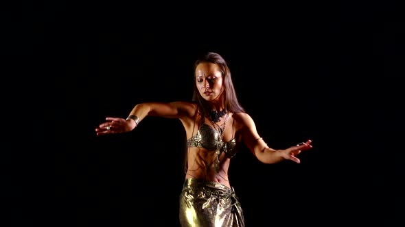 Slender European Girl in a National Oriental Costume Dancing on a Black Background Belly Dance