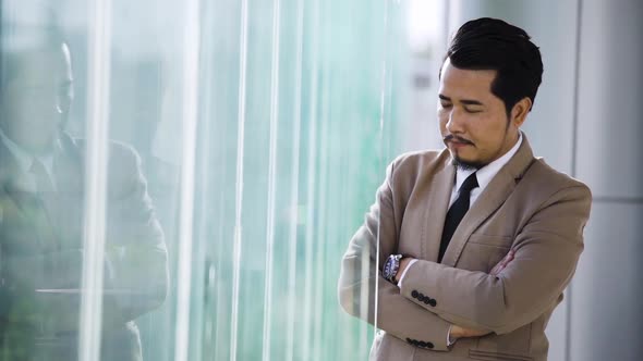 slow-moiton of young business man with arms crossed in office