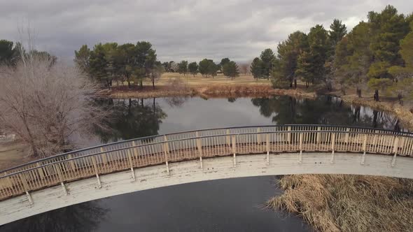 Aerial Fly Over of bridge at Apollo Park Lake in Lancaster, California, autumn day