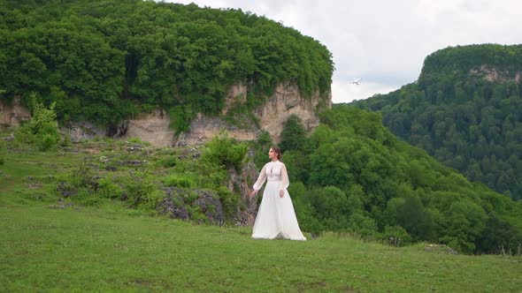 A Woman in a Wedding Dress and Black Boots in the Mountains
