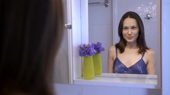 Pretty Brunette Liking Her Look in the Mirror