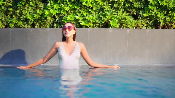 Young asian woman enjoy around outdoor swimming pool for leisure