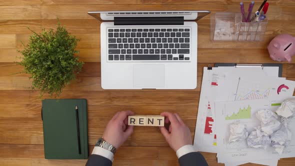 Wooden cubes make up the word rent on an office desktop. Word rent is made up of wooden cubes. Conce