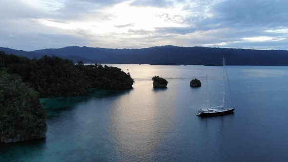 Aerial View Of Triton Bay: Boat On Turquoise Sea And Green Tropical Trees In Kaimana Islands