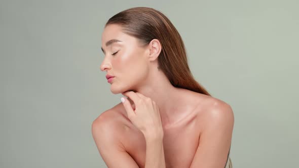 Beautiful Young Woman with Clean Fresh Skin Standing Over Light Grey Background