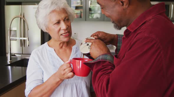 Senior African American and mixed race woman drinking a beverage at home