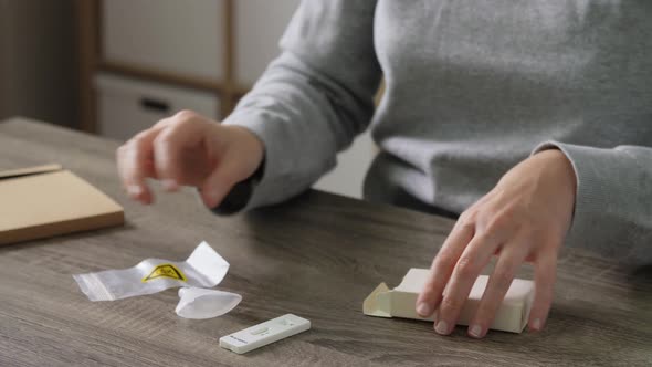 Woman Unpacking Coronavirus Test Kit at Home