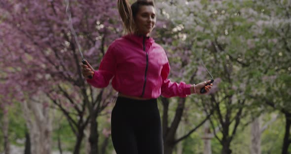 Pretty Sporty Woman Jumping Rope in the Park Slow Motion