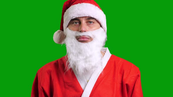 Santa Claus in Red Suit Pointing Aside on Green Chroma Key Background