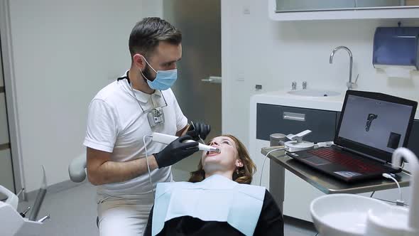 The Dentist Scans the Patient's Teeth with a 3d Scanner