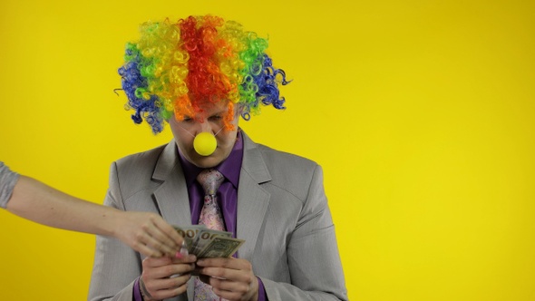 Clown Businessman Entrepreneur Counts Money Income. Hand Steals Cash From Man