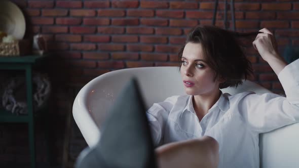 Glamorous Lady Plays with Her Hair During Relaxing in a Bath