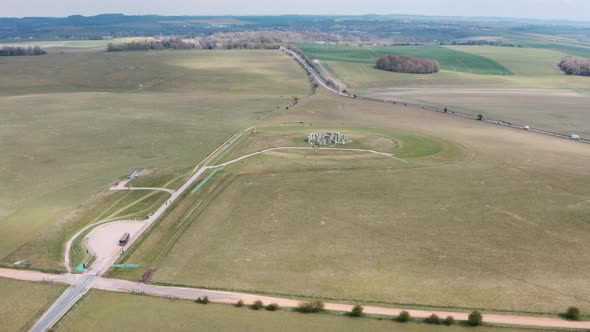 Dolly forward drone shot of Stonehenge towards A303 highway