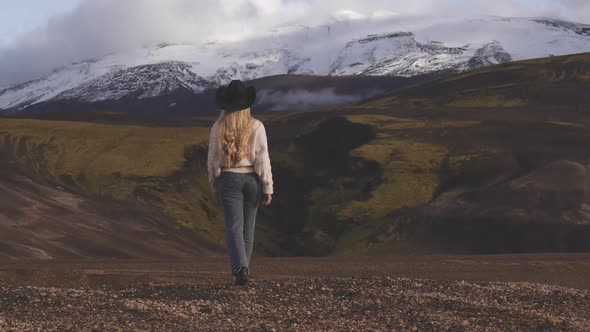 Blond Woman In Cowboy Hat Looking At Mountains