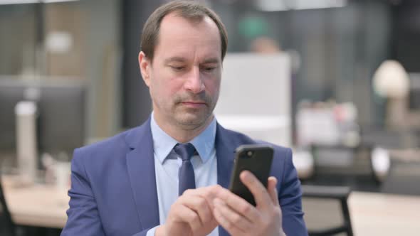 Portrait of Businessman Using Smartphone