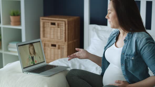 Tracking left video of pregnant woman talking with doctor online. Shot with RED helium camera in 8K 