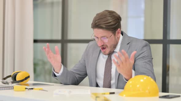 Upset Middle Aged Engineer Feeling Worried While Sitting in Office