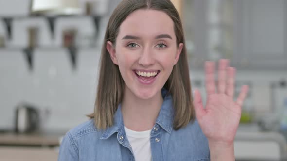 Portrait of Attractive Young Woman Waving at the Camera 