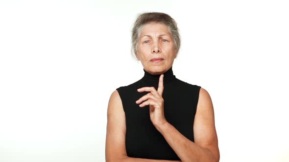 in Slowmotion Senior Serious Woman Thinking Hard Gesturing with Index Finger Finally Figure Out