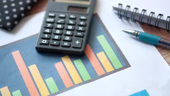 Financial Graph, Calculator and Notepad on Table 