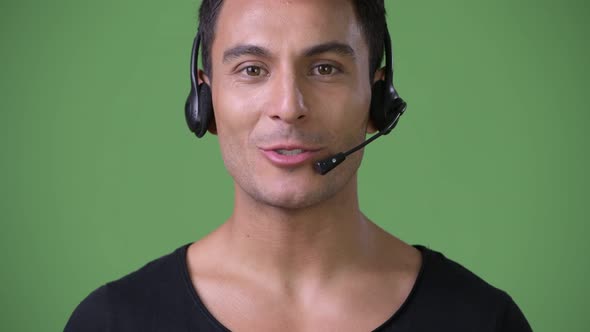 Young Handsome Hispanic Man Against Green Background