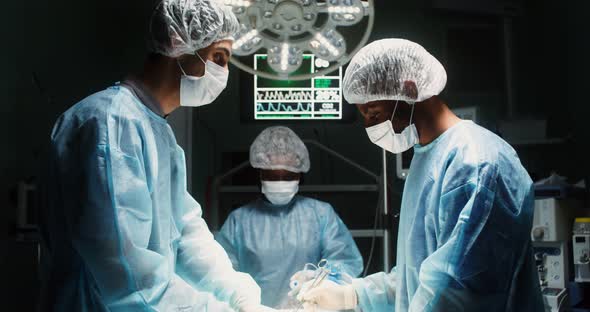 A Team of Surgeons Perform an Operation in a Bright Operating Room