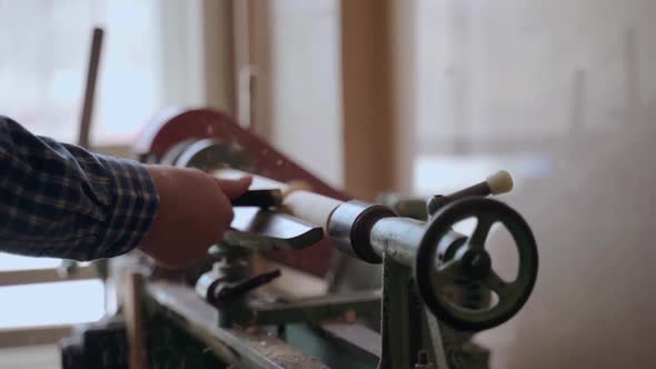 Person Carving Chisel Candlestick on a Lathe