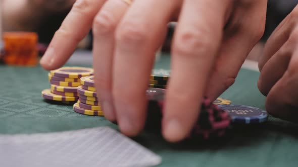  A Man Bets on Chips While Playing Poker