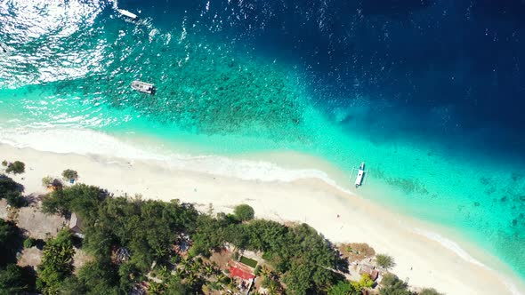 Tropical above tourism shot of a white sandy paradise beach and turquoise sea background 