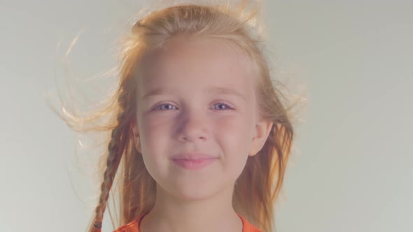 Close up of a little girl's face blowing in the wind