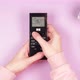 Hands of a young woman hold the remote control from the air conditioner and adjust the temperature - VideoHive Item for Sale