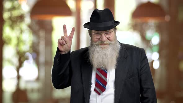 Old Bearded Man in Suit Showing Victory Gesture