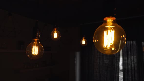 Big Vintage Incandescent Light Bulbs Hanging in the Dark Kitchen