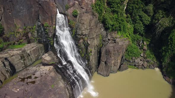 Aerial View of a Waterfall on a Steep Rocky Cliff in the Jungle on Summer Day