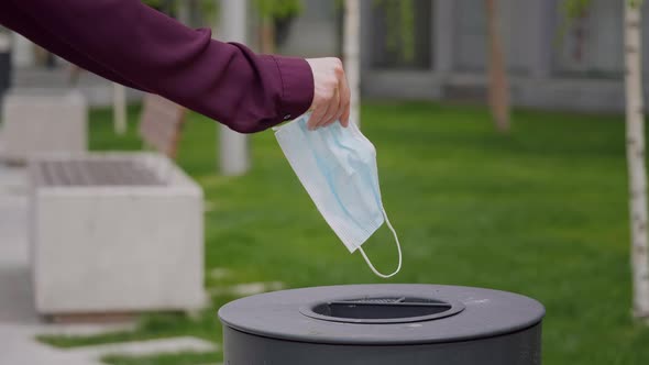 Close up slow motion mask throw in a trash.