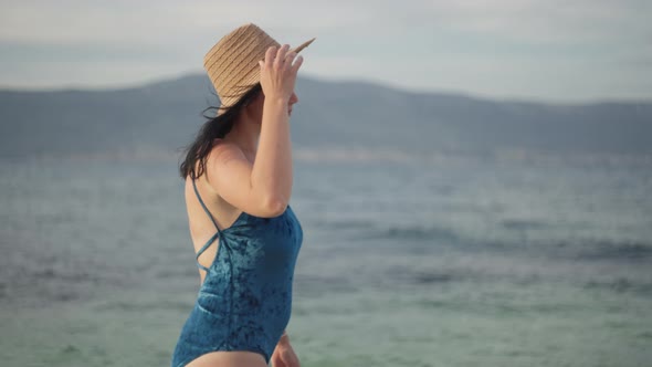 Caucasian Girl in a Bathing Suit Walks By the Sea