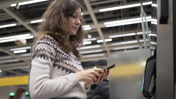 Brunette Woman Pays at ATM Using Pay Pass in Smartphone