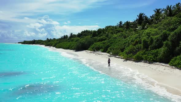 Lady alone happy and smiling on perfect shore beach lifestyle by clear water with white sandy backgr