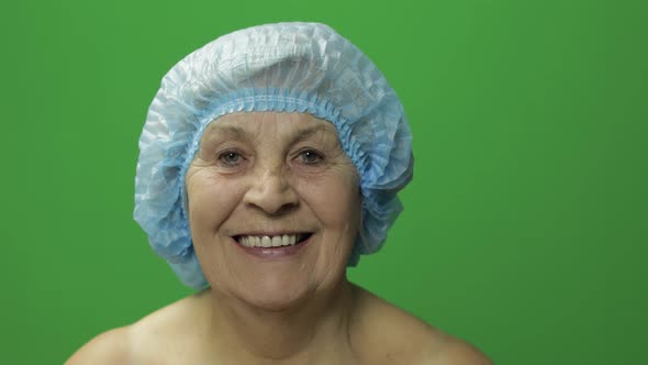 Elderly Female in Protective Hat. Doctor Making Facial Injections for Patient