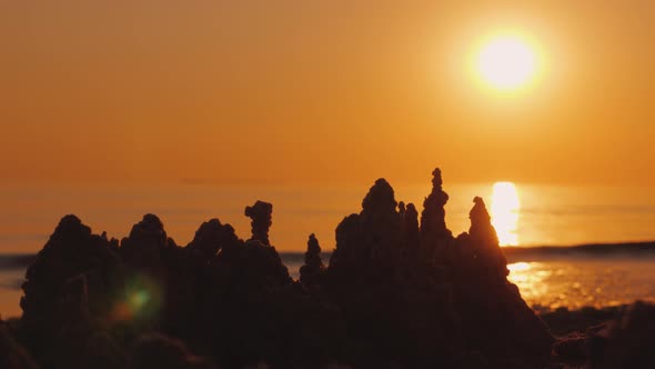 Sand Castle on the Beach, in the Background the Sun Sets