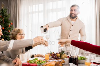 hristmas dinner together with mature man pouring champagne, copy space