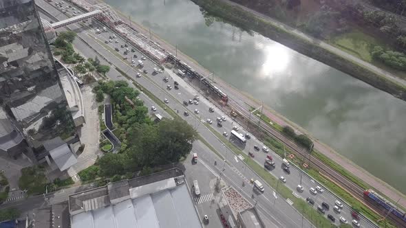 Mirrored two Building and river with cars and trains crossing drone 4k