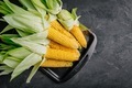 Fresh sweet golden corn on cobs on dark gray stone background - PhotoDune Item for Sale