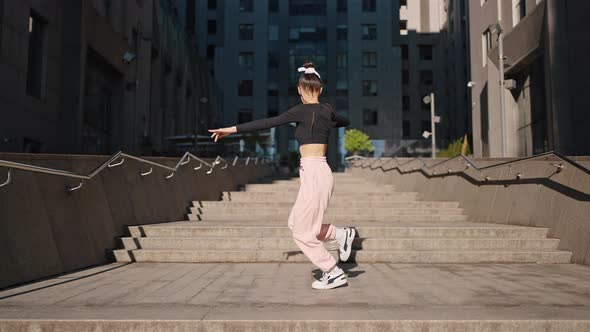 Young Woman Stretches Out Body Through Dance on Stairs