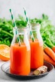 Fresh carrot, ginger and orange drink in glass bottles on a gray stone background - PhotoDune Item for Sale