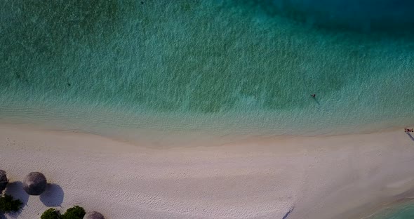 Natural fly over travel shot of a white sand paradise beach and blue sea background in 4K