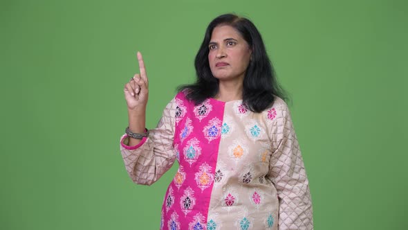Mature Beautiful Indian Woman Thinking While Pointing Finger Up