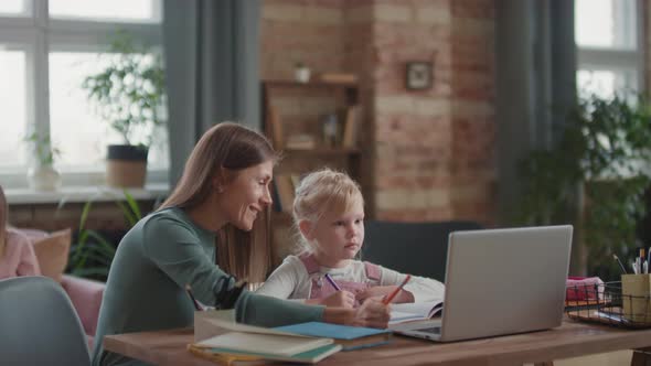 Woman Teaching Girl Using Laptop