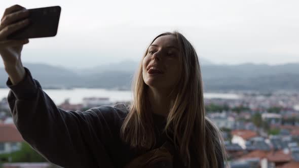 Long Haired Woman Takes a Photo with a Smartphone in Her Hands